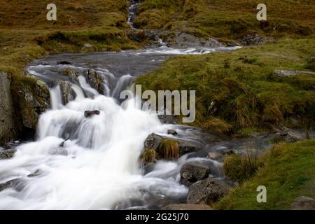 Ein Gebirgsbach fließt vom Kirkstone Pass im Lake District in Cumbria, England, hinunter Stockfoto