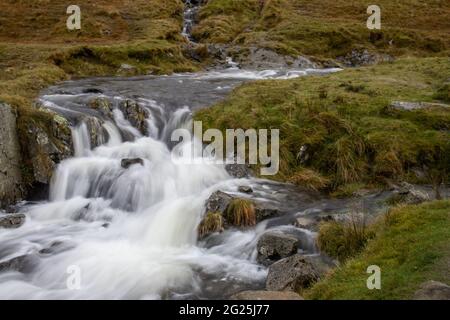 Ein Gebirgsbach fließt vom Kirkstone Pass im Lake District in Cumbria, England, hinunter Stockfoto