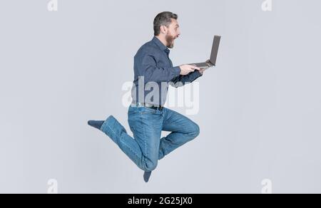 Überrascht energisch springenden Mann läuft online auf Laptop arbeiten beeilen Sie sich zum Einkaufen, Geschäft Stockfoto