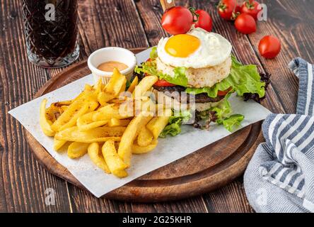 Koreanischer Burger mit Ei, Reis und frittierten Pommes auf Holzgrund Stockfoto