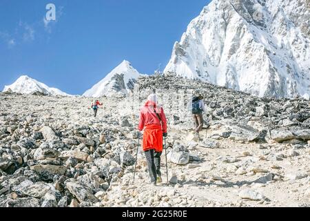 Frau in Rot geht auf den Gipfel des Kala Patthar Stockfoto