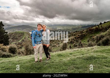 Aktives Paar mittleren Alters in Neuseeland, das mit Bergen im Hintergrund steht Stockfoto