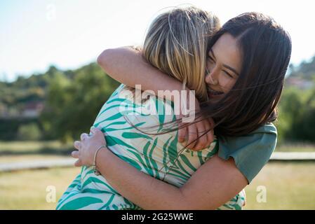 Lächelnde Mädchen umarmen einander Stockfoto