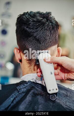 Ein Friseur schneidet einem Jungen die Haare maschinell Stockfoto