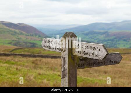 Hölzerner Wegweiser in der Nähe von Dent, der auf High Moss und Dent zeigt Stockfoto