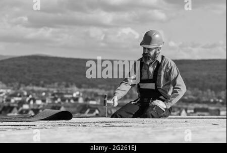 Einbau des Flachdachs. Dachdecker beim Bau eines neuen Dachs. Schätzen Sie den Materialbedarf für Projekte. Installation von Dachmaterialien Wärmedämmung. Mann Stockfoto