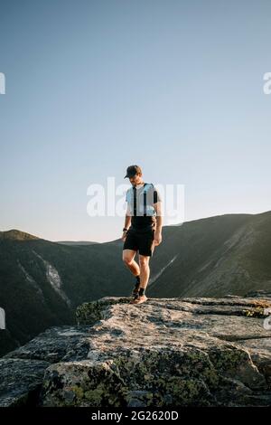 Männliche Wanderläufer wandern auf Granit in den White Mountains, New Hampshire Stockfoto