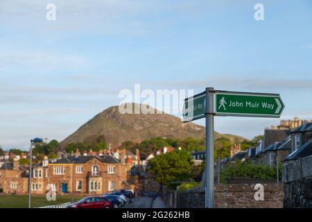 Ein Wegweiser für den John Muir Way in Nord-Berwick mit dem Gesetz im Hintergrund Stockfoto