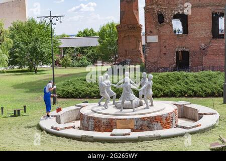 WOLGOGRAD, RUSSLAND - 17. AUGUST 2020: Ein Mitarbeiter fegt den Bereich um den Brunnen Dancing Children. Ruiniert während des Weltkrieges 2 rote Ziegel mil Stockfoto