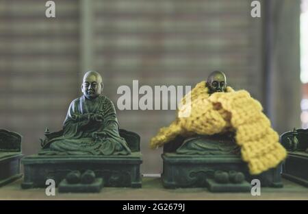 Kleine buddhistische Bronzestatuen mit gestrickten Schals, von denen angenommen wird, dass sie im Daisho-in-Tempel in Miyajima, H, die Träume der Gläubigen wahr werden lassen Stockfoto