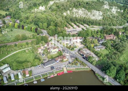 Luftaufnahme von Booten, die auf dem Fluss Arun bei Amberley in West Sussex England mit der Straßenbrücke über den Fluss festgemacht sind. Stockfoto