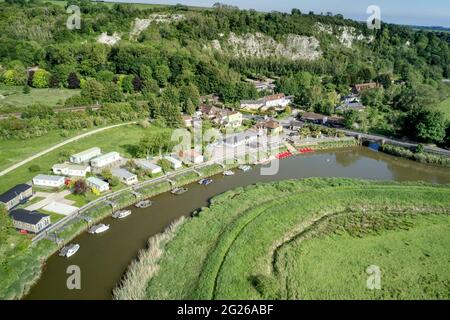 Luftaufnahme von Booten, die auf dem Fluss Arun in Amberley in West Sussex England mit Kreidefelsen im Hintergrund festgemacht sind. Stockfoto