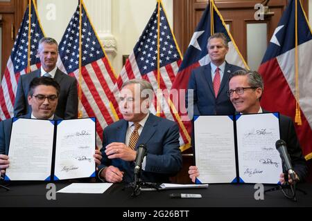 Austin, TX, USA. Juni 2021. Texas Gov. GREG ABBOTT posiert nach der Unterzeichnung von zwei Gesetzesvorlagen zur Stärkung des texanischen Stromnetzes und der Infrastruktur, die als Notfälle auf seiner legislativen Tagesordnung standen. Die Gesetzesvorlagen waren eine Reaktion auf den Wintersturm im Februar, der das texanische Stromnetz fast ausschlug. Links sehen Sie Rep. CHRIS PADDIE, R-Marshall, rechts Senator KELLY HANCOCK, R-North Richland Hills. Quelle: Bob Daemmrich/ZUMA Wire/Alamy Live News Stockfoto