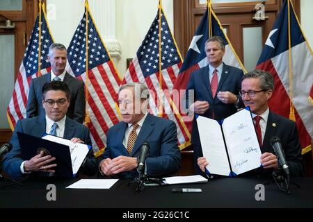 Austin, TX, USA. Juni 2021. Texas Gov. GREG ABBOTT hält an, nachdem er zwei Gesetzesvorlagen zur Stärkung des texanischen Stromnetzes und der Infrastruktur unterzeichnet hat, die auf seiner legislativen Tagesordnung standen. Die Gesetzesvorlagen waren eine Reaktion auf den Wintersturm im Februar, der das texanische Stromnetz fast ausschlug. Links sehen Sie Rep. CHRIS PADDIE, R-Marshall, rechts Senator KELLY HANCOCK, R-North Richland Hills. Quelle: Bob Daemmrich/ZUMA Wire/Alamy Live News Stockfoto