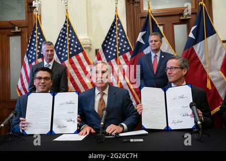 Austin, TX, USA. Juni 2021. Texas Gov. GREG ABBOTT posiert nach der Unterzeichnung von zwei Gesetzesvorlagen zur Stärkung des texanischen Stromnetzes und der Infrastruktur, die als Notfälle auf seiner legislativen Tagesordnung standen. Die Gesetzesvorlagen waren eine Reaktion auf den Wintersturm im Februar, der das texanische Stromnetz fast ausschlug. Links sehen Sie Rep. CHRIS PADDIE, R-Marshall, rechts Senator KELLY HANCOCK, R-North Richland Hills. Quelle: Bob Daemmrich/ZUMA Wire/Alamy Live News Stockfoto