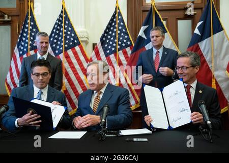 Austin TX USA, Juni 8 2021: Texas Gov. Greg Abbott posiert nach der Unterzeichnung von zwei Gesetzesvorlagen zur Stärkung des texanischen Stromnetzes und der Infrastruktur, die als Notfälle auf seiner legislativen Tagesordnung standen. Die Gesetzesvorlagen waren eine Reaktion auf den Wintersturm im Februar, der Teile des texanischen Stromnetzes ausschlug und Millionen von Texanern tagelang ohne Strom auskam. Links sehen Sie Rep. Chris Paddie, R-Marshall, rechts Senator Kelly Hancock, R-North Richland Hills. Kredit: Bob Daemmrich/Alamy Live Nachrichten Stockfoto