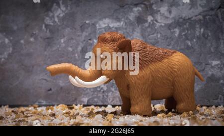 Spielzeug-Mammut auf steinigem Hintergrund Stockfoto