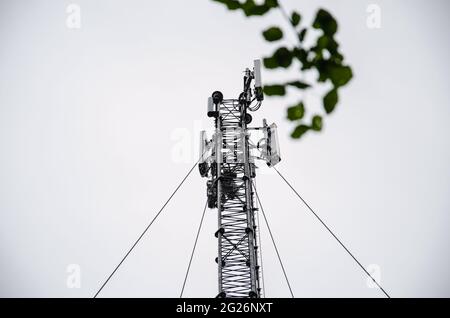 Telekommunikationsingenieur, der am Hochturm arbeitet, riskiert Arbeiten mit hohem Arbeitsaufwand, Techniker, der mit Sicherheitsausrüstung am Turm arbeitet, Sky-Hintergrund. Stockfoto