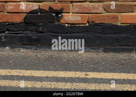 Wokingham, Großbritannien. Juni 2021. Eine schwarze Katzenschablone mit aufklebenden Augen von einem Straßenkünstler, der von anerkennenden Anwohnern als „Catsy“ bezeichnet wird. Es wird angenommen, dass etwa 30-40 solcher schwarzen Katzenschablonen vom anonymen Straßenkünstler durch die Stadt gesprüht werden. Kredit: Mark Kerrison/Alamy Live Nachrichten Stockfoto