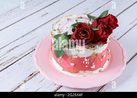 Schokoladenkuchen mit Schweizer Baiser Buttercreme, mit roten Blumen zum Verzieren. Stockfoto