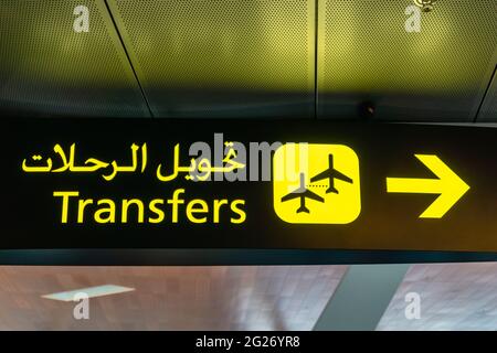 Schild für den Flughafentransfer - Schild für internationale Fluginformationen am Flughafen in Englisch und Arabisch Stockfoto