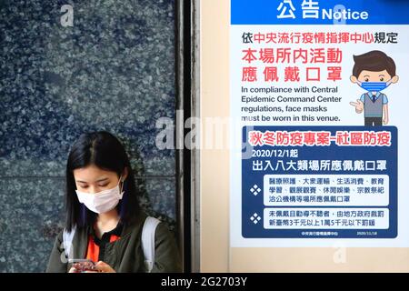 Taipei, Taioei, Taiwan. Mai 2021. Ein Student mit einer Gesichtsmaske, der neben einer Bekanntmachung des obligatorischen Maskentragens steht, da Taiwan die Beschränkungen für große Versammlungen und Veranstaltungen nach einem Anstieg der Covid-19-Fälle verschärft hat. Quelle: Daniel Ceng Shou-Yi/ZUMA Wire/Alamy Live News Stockfoto