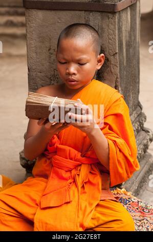 Junger buddhistischer Mönch liest von einer Holztafel in Angkor Wat. Provinz Siem Reap, Kambodscha. Quelle: Kraig lieb Stockfoto