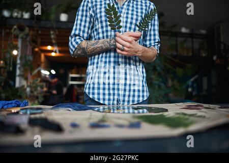 Junger Mann im karierten Hemd mit grünen Pflanzen Stockfoto