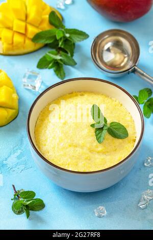 Eis, süßer Snack oder Dessert. Hausgemachtes Mangofrucht-Eis, sommerliches Tropenfruchtsorbet auf einem Steintisch. Stockfoto