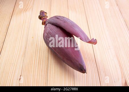 Frische Bananenblüte oder Bananenblüte, essbares Gemüse, das hauptsächlich in Südostasien verwendet wird, auf einem Holztisch mit Struktur angeordnet Stockfoto