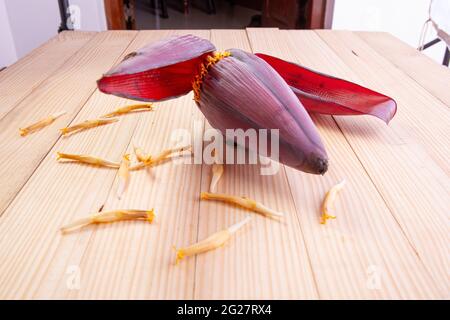 Frische Bananenblüte oder Bananenblüte, essbares Gemüse, das hauptsächlich in Südostasien verwendet wird, auf einem Holztisch mit Struktur angeordnet Stockfoto