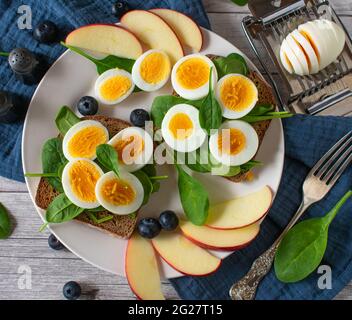 Ein Teller mit gesunden Sandwiches und Obst auf einem Tisch. Tabellenansicht von oben Stockfoto