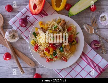 Ein Teller mit glutenfreien Pasta-Gericht mit Fisch und Gemüse auf rustikalem und Holztisch Hintergrund Stockfoto