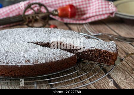 Köstliche schwedische Schokoladenkuchen kladdkaka ohne Backpulver gebacken und serviert auf einem Kühlregal auf rustikalen und hölzernen Tisch Hintergrund Stockfoto