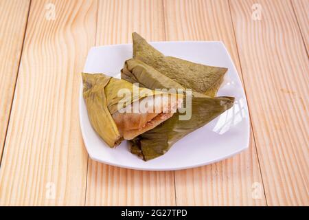 Ela Ada oder gedämpfte süße Reisdumblings, gedämpfte Reiskuchen in Bananenblatt verpackt, Kerala traditionelle Snacks, in einer weißen Keramikplatte angeordnet Stockfoto