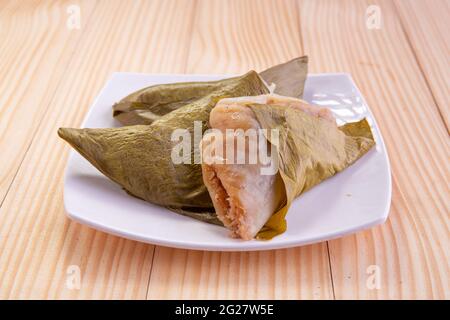 Ela Ada oder gedämpfte süße Reisdumblings, gedämpfte Reiskuchen in Bananenblatt verpackt, Kerala traditionelle Snacks, in einer weißen Keramikplatte angeordnet Stockfoto