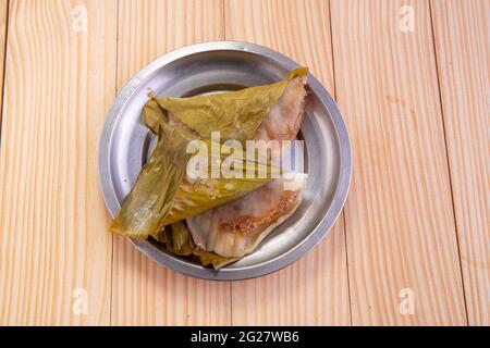 Ela Ada oder gedämpfte süße Reisdumblings, gedämpfte Reiskuchen in Bananenblatt verpackt, Kerala traditionelle Snacks Artikel, in einer Stahlplatte angeordnet. Stockfoto