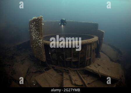 Ein Tauchler, der eine gepanzerte barbette von HMS Audacious erkundet, die im 1. Weltkrieg versenkt wurde. Stockfoto