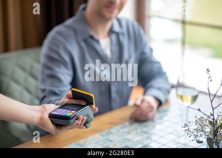 Mann mit Smartphone macht Scheck Zahlung. Stockfoto