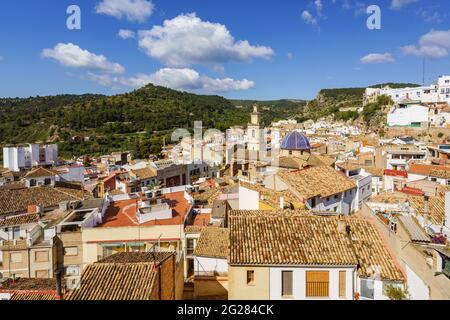 Panoramablick auf Buñol von der Burg aus. Kirche von San Pedro Apostol. Stadt in einem grünen Tal in Spanien. Stockfoto