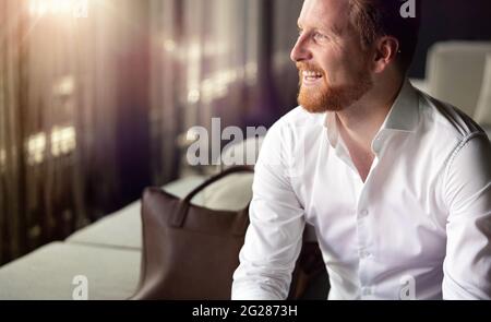 Porträt eines hübschen jungen Geschäftsmannes lächelnd Stockfoto