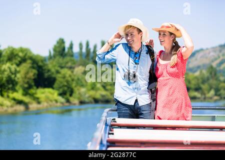 Glückliches Paar auf Flusskreuzfahrt trägt eine Mütze im Sommer ihre Zeit genießen. Stockfoto