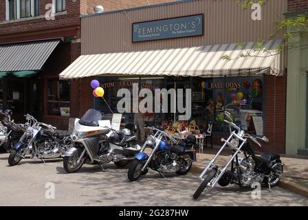 ST. CHARLES, VEREINIGTE STAATEN - 29. Apr 2009: Motorräder, die auf einer Stadtstraße vor einem Geschäft in St. Charles, Missouri, geparkt sind Stockfoto