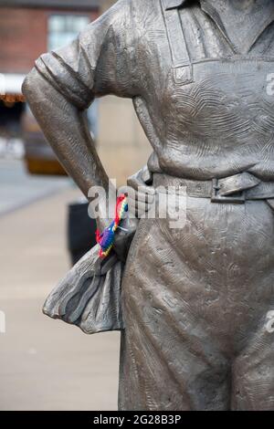 Sheffield UK: 17. April 2021: Buntes Pride-Armband am Handgelenk der Women of Steel Statue am Barkers Pool Stockfoto