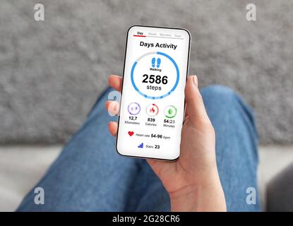 Weibliche Hand hält Smartphone mit Gesundheits-App auf dem Bildschirm Stockfoto