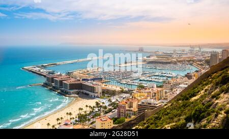 Alicante, Strand und Hafen mit Luxusyachten und Segelbooten von oben bei Sonnenuntergang. Blick auf schöne touristische Stadt in der Costa Blanca Region auf Stockfoto