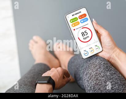 Frau mit Smartwatch und Telefon in der Hand Stockfoto