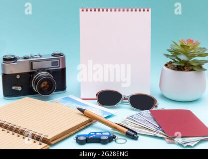 Reiseplan, Reise, Tourist Mockup - Brille, Notizblock, Stift, Kamera, Geld, Bargeld, Pässe und leerer vertikaler weißer Notizblock für Ihren Schriftzug Stockfoto