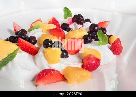 Sommerfrühstück Dessert mit frischem Obst auf Eis oder Joghurt gesunde Ernährung Lebensmittel vitaminreich. Weiße Meringue-Schlagsahne mit Früchten. Gesund Stockfoto