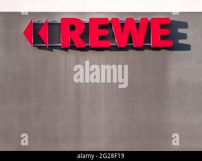 NEUWIED, DEUTSCHLAND - 12. Nov 2020: Neuwied, Deutschland - 12. November 2020: Rotes REWE Label mit Dreiecken als Richtungszeichen außen an einer Wand - copy Spa Stockfoto